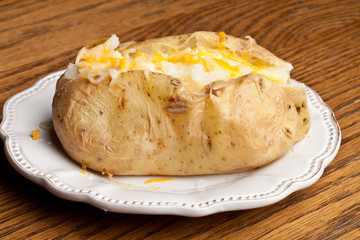 Baked potato topped with butter and cheese - top view