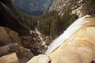 Looking down from the top of a waterfall over a majestic valley