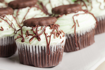 Irish Mint Chocolate Cupcakes - Chocolate cake with chocolate mint cookie pieces filled with mint topped with a green mint buttercream frosting, drizzled with dark chocolate, and a cookie thin cookie