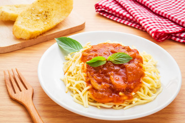Spaghetti with chicken in tomato sauce and garlic bread