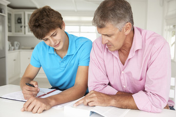 Father helping teenage son with homework