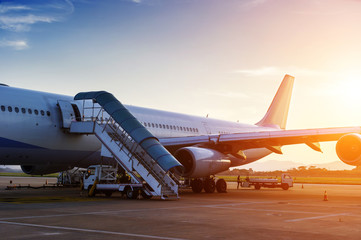 Fototapeta na wymiar Airplane near the terminal in an airport at the sunset