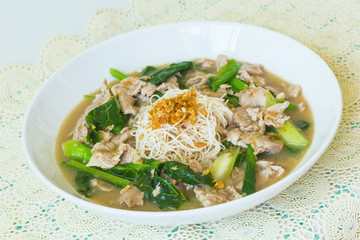 vermicelli  noodles topped with pork and kale