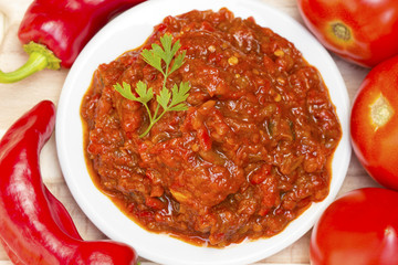 Lutenica pepper and tomato relish on wooden background