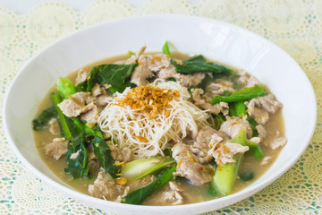 vermicelli  noodles topped with pork and kale