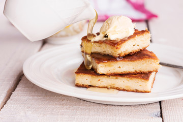 pieces cheesecake on a round plate and a cream, pour honey