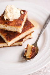 cheesecake on a round plate and a spoon with piece
