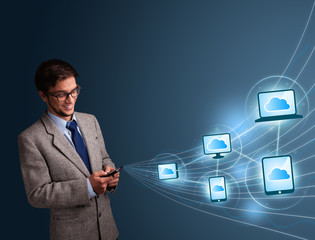 Handsome man typing on smartphone with cloud computing