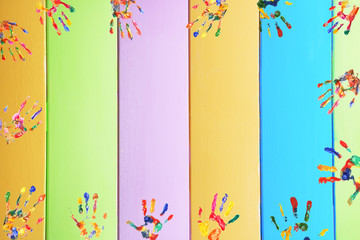 Frame of color hands print on wooden background