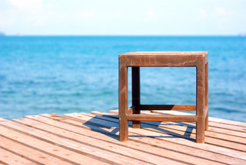 Fototapeta na wymiar chair on the wooden deck by the sea