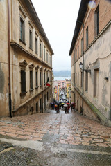 Tourists walking up stairs in street, Portoferraio, Italy