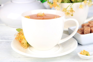 Obraz na płótnie Canvas Tasty herbal tea with linden flowers on wooden table