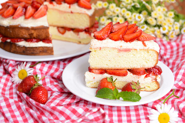 Delicious biscuit cake with strawberries on table close-up