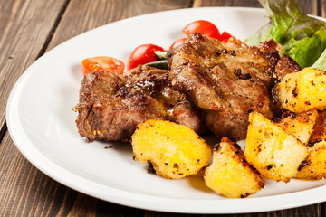 Steaks, baked potatoes and vegetable salad