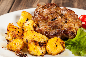 Steaks, baked potatoes and vegetable salad