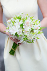 Young bride holding in her hands wedding flowers