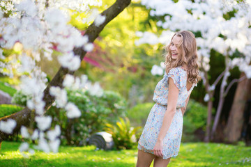 Young woman in blooming cherry garden