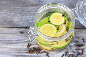 Pickled limes and cloves in glass jar,