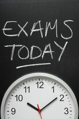 Exams Today written on a blackboard above a clock