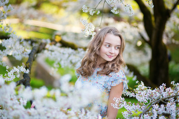 Young woman in blooming cherry garden
