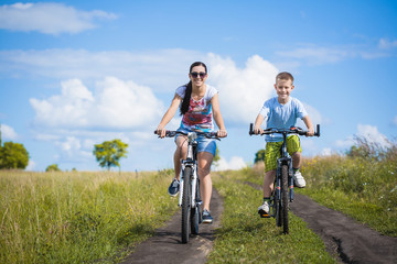 mother and son riding bicycle in the field