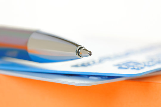Pen and Credit Cards on an Orange Note Pad