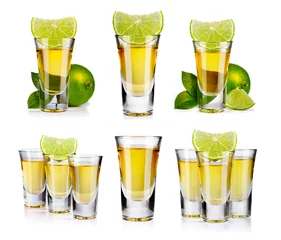 Fototapeten Set of gold tequila shot with lime fruits isolated © Serhiy Shullye