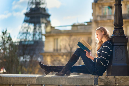 Beautiful woman in Paris, reading a book