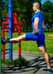 Handsome healthy man exercising at the city park