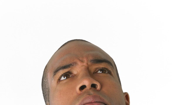 Closeup of cropped man's face looking up and thinking