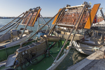 Fototapeta na wymiar fishing boats in harbor - machine for the processing of clams