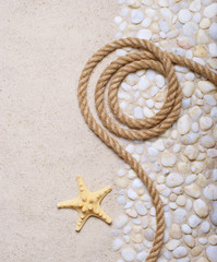 Fototapeta na wymiar Rope and starfish on sea pebbles