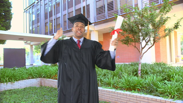 African American man with graduation gown kissing diploma