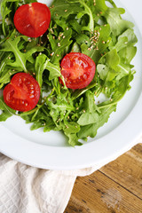 Green salad made with  arugula, tomatoes and sesame