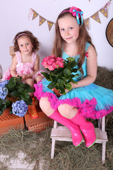 Beautiful small girls in petty skirts holding flowers