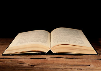 Old book on table on black background