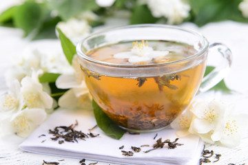 Cup of tea with jasmine on table close-up