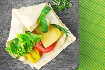 Veggie wrap filled with chicken and fresh vegetables on table