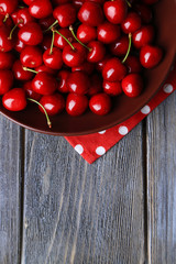 Sweet cherries  on plate on wooden background