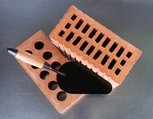 Metal tool for building and bricks on bright background