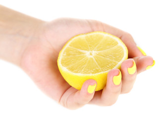 Female hand with stylish colorful nails holding fresh lemon,