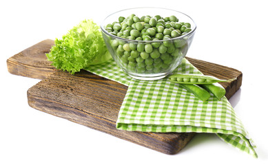 Fresh peas in glass bowl on wooden board, isolated on white