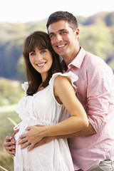 Obraz premium Expectant couple outdoors in countryside