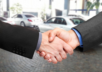 Business handshake to close the deal after buying a car