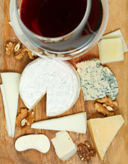 top view of red wine glass and assortment cheeses