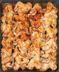 many roasted spicy chicken wings on hot tray