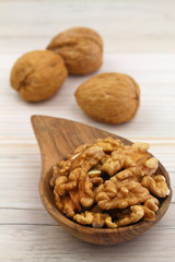 Walnuts with and without shell on wooden background