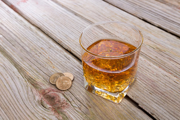 Tumbler of whiskey and tip on a bar counter