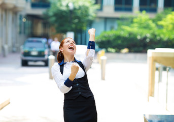 Businesswoman celebrating success outside corporate office
