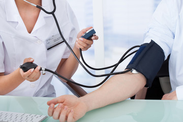 Doctor Checking Blood Pressure Of Businessman